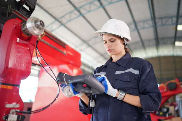 stock image Robotics engineer working on maintenance of modern robotic arm in factory warehouse