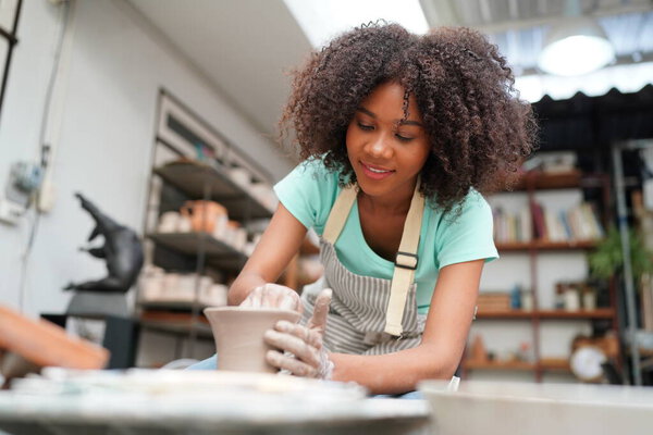 Young Afro girl in pottery workshop, Business owner. 