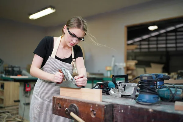 stock image Young beautiful woman doing work in the carpenter DIY workshop room. Small Business owner, young woman who working at furniture factory.