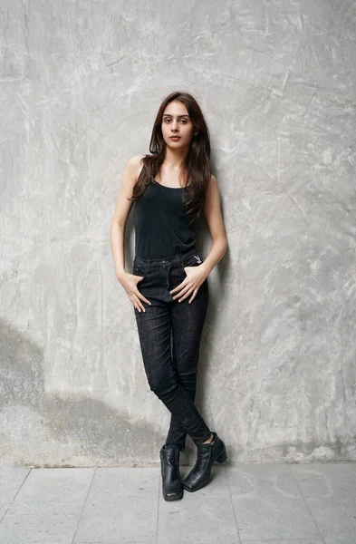 Moda Modeli stüdyoda. Şık, siyah elbiseli, güzel, seksi kadın. Genç, muhteşem Hintli kadın model, duvarın arkasında siyah kıyafetler giyiyor..