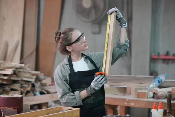 Genç bir kadının küçük işleri. Mobilya atölyesinde çalışan güzel genç bayan.