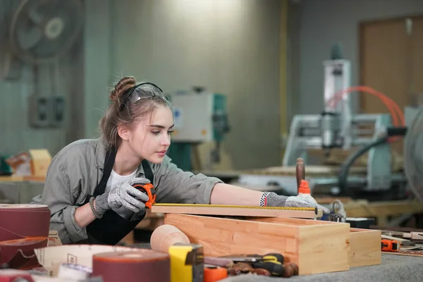 Genç bir kadının küçük işleri. Mobilya atölyesinde çalışan güzel genç bayan.