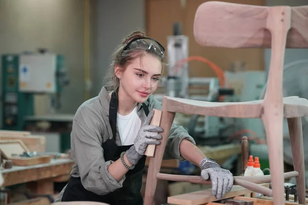 Marangoz DIY atölyesinde çalışan genç ve güzel bir kadın. Küçük işletme sahibi, mobilya fabrikasında çalışan genç bir kadın..