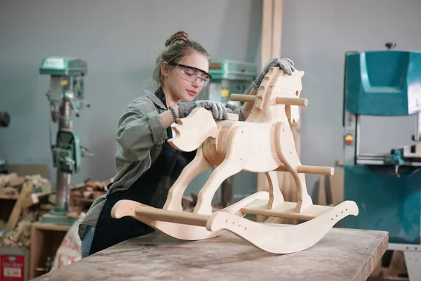 Marangoz DIY atölyesinde çalışan genç ve güzel bir kadın. Küçük işletme sahibi, mobilya fabrikasında çalışan genç bir kadın..