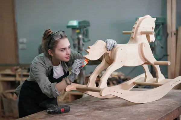 Genç bir kadının küçük işleri. Mobilya atölyesinde ahşabı ölçen genç ve güzel bir kadın işçi..