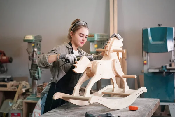 Marangoz DIY atölyesinde çalışan genç ve güzel bir kadın. Küçük işletme sahibi, mobilya fabrikasında çalışan genç bir kadın..