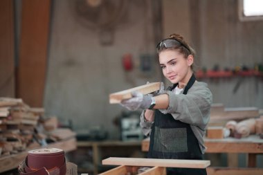 Marangoz DIY atölyesinde çalışan genç ve güzel bir kadın. Küçük işletme sahibi, mobilya fabrikasında çalışan genç bir kadın..