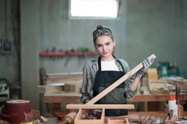 Genç bir kadının küçük işleri. Mobilya atölyesinde çalışan güzel genç bayan.