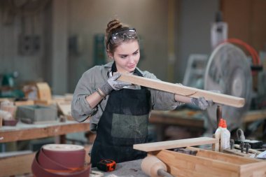 Genç bir kadının küçük işleri. Mobilya atölyesinde çalışan güzel genç bayan.