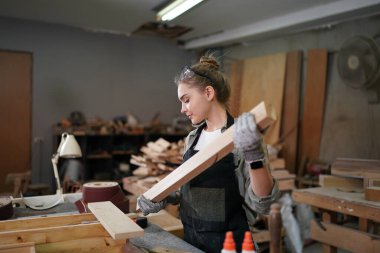Marangoz DIY atölyesinde çalışan genç ve güzel bir kadın. Küçük işletme sahibi, mobilya fabrikasında çalışan genç bir kadın..