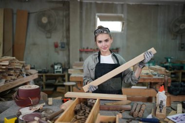 Genç bir kadının küçük işleri. Mobilya atölyesinde çalışan güzel genç bayan.