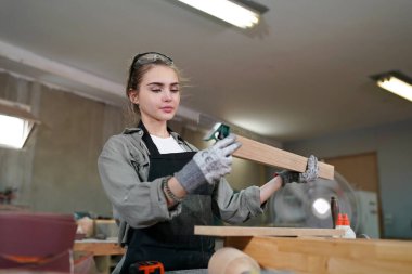 Genç bir kadının küçük işleri. Mobilya atölyesinde çalışan güzel genç bayan.