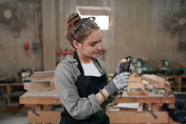 Genç bir kadının küçük işleri. Mobilya atölyesinde çalışan güzel genç bayan.