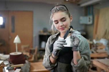 Genç bir kadının küçük işletmesi. Mobilya atölyesinde çalışan güzel genç bayan.