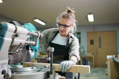 Marangoz DIY atölyesinde çalışan genç ve güzel bir kadın. Küçük işletme sahibi, mobilya fabrikasında çalışan genç bir kadın..