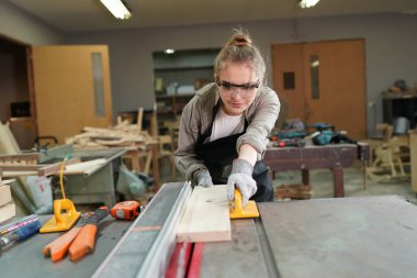 Genç bir kadının küçük işleri. Mobilya atölyesinde çalışan güzel genç bayan.