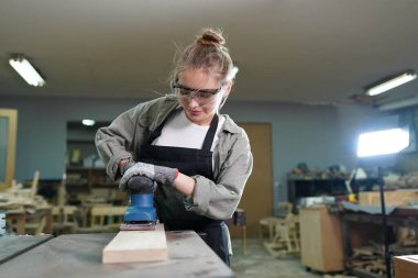 Genç bir kadının küçük işletmesi. Mobilya atölyesinde çalışan güzel genç bayan.