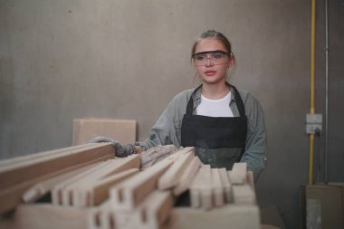 Genç bir kadının küçük işleri. Mobilya atölyesinde ahşabı ölçen genç ve güzel bir kadın işçi..