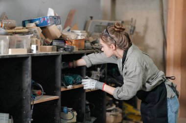 Genç bir kadının küçük işleri. Mobilya atölyesinde çalışan güzel genç bayan.