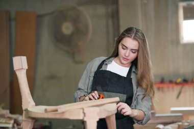 Genç bir kadının küçük işletmesi. Mobilya atölyesinde çalışan güzel genç bayan.