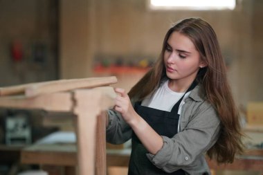 Genç bir kadının küçük işleri. Mobilya atölyesinde çalışan güzel genç bayan.