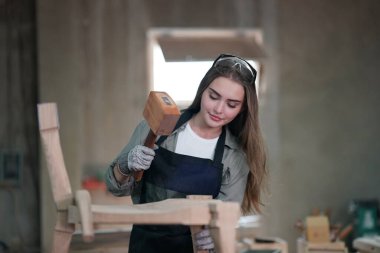 Genç bir kadının küçük işletmesi. Mobilya atölyesinde çalışan güzel genç bayan.