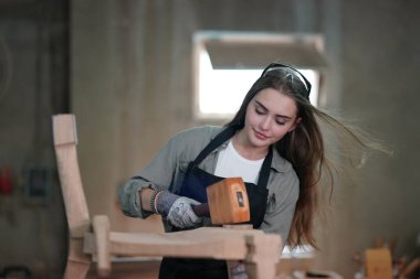 Genç bir kadının küçük işletmesi. Mobilya atölyesinde çalışan güzel genç bayan.