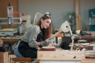Marangoz DIY atölyesinde çalışan genç ve güzel bir kadın. Küçük işletme sahibi, mobilya fabrikasında çalışan genç bir kadın..