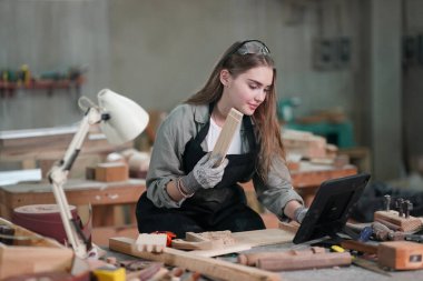 Marangoz DIY atölyesinde çalışan genç ve güzel bir kadın. Küçük işletme sahibi, mobilya fabrikasında çalışan genç bir kadın..