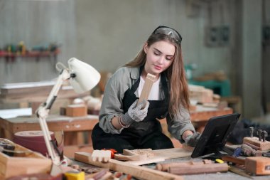 Genç bir kadının küçük işleri. Mobilya atölyesinde çalışan güzel genç bayan.