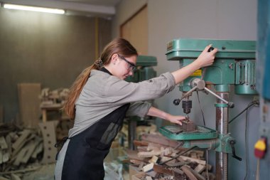 Genç bir kadının küçük işleri. Mobilya atölyesinde çalışan güzel genç bayan.