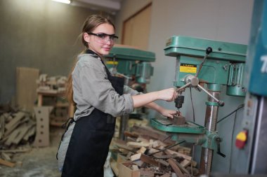 Genç bir kadının küçük işleri. Mobilya atölyesinde çalışan güzel genç bayan.