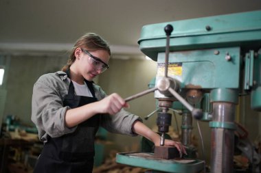 Genç bir kadının küçük işleri. Mobilya atölyesinde ahşabı ölçen genç ve güzel bir kadın işçi..