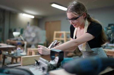 Genç bir kadının küçük işletmesi. Mobilya atölyesinde çalışan güzel genç bayan.