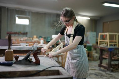 Genç bir kadının küçük işleri. Mobilya atölyesinde çalışan güzel genç bayan.