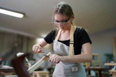 Genç bir kadının küçük işletmesi. Mobilya atölyesinde çalışan güzel genç bayan.