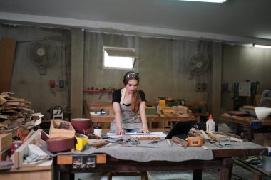 Genç bir kadının küçük işleri. Mobilya atölyesinde çalışan güzel genç bayan.