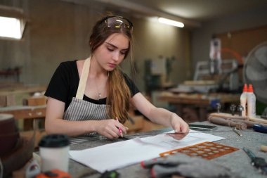 Genç bir kadının küçük işleri. Mobilya atölyesinde çalışan güzel genç bayan.