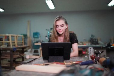 Genç bir kadının küçük işleri. Mobilya atölyesinde ahşabı ölçen genç ve güzel bir kadın işçi..