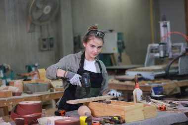 Genç bir kadının küçük işleri. Mobilya atölyesinde çalışan güzel genç bayan.