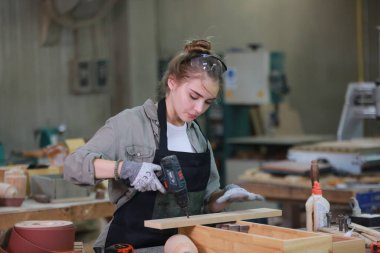 Genç bir kadının küçük işleri. Mobilya atölyesinde çalışan güzel genç bayan.