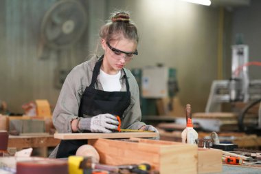 Genç bir kadının küçük işleri. Mobilya atölyesinde çalışan güzel genç bayan.