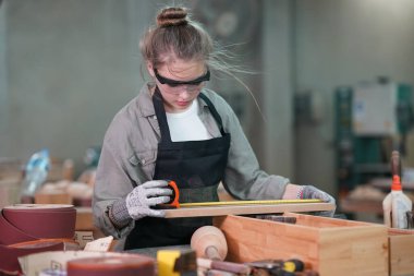 Genç bir kadının küçük işleri. Mobilya atölyesinde çalışan güzel genç bayan.