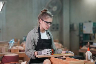 Genç bir kadının küçük işleri. Mobilya atölyesinde çalışan güzel genç bayan.