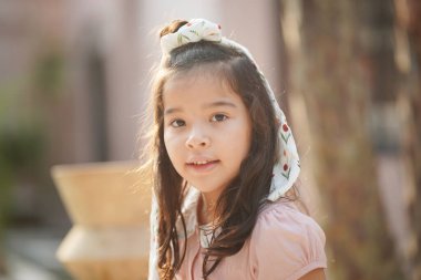 Gülümseyen küçük bir çocuğun portresi. Gülümseyen Asyalı Kız Kafede eğleniyor.