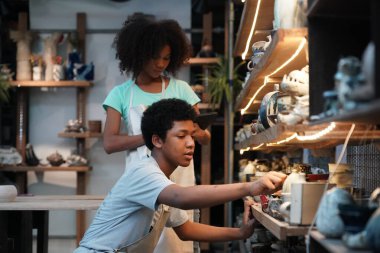 Genç Afro kız ve oğlan çömlek atölyesinde, işyeri sahibi.. 