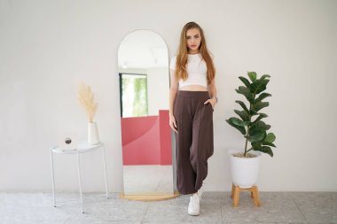 Kadın minimumda poz veriyor. Güzel, sarışın, beyaz kadın. İç mekânda poz veriyor..