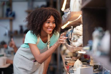 Çömlek atölyesindeki genç Afro kız, işyeri sahibi.