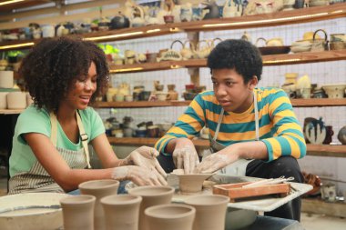 Genç Afro kız ve oğlan çömlek atölyesinde, işyeri sahibi.. 