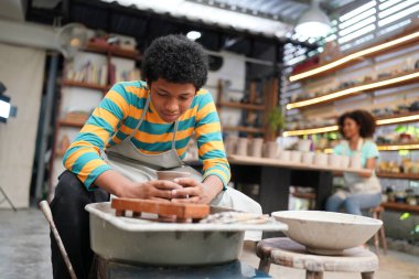 Genç Afro ergen el çömlekçisi çömlek atölyesinde kilden vazo yapıyor.
